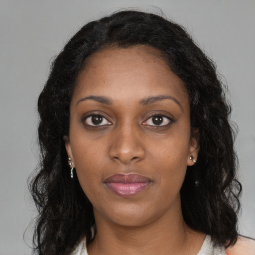 Joyful black young-adult female with long  black hair and brown eyes