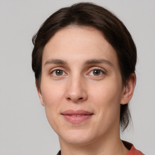 Joyful white young-adult female with medium  brown hair and grey eyes