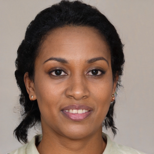 Joyful black young-adult female with medium  brown hair and brown eyes