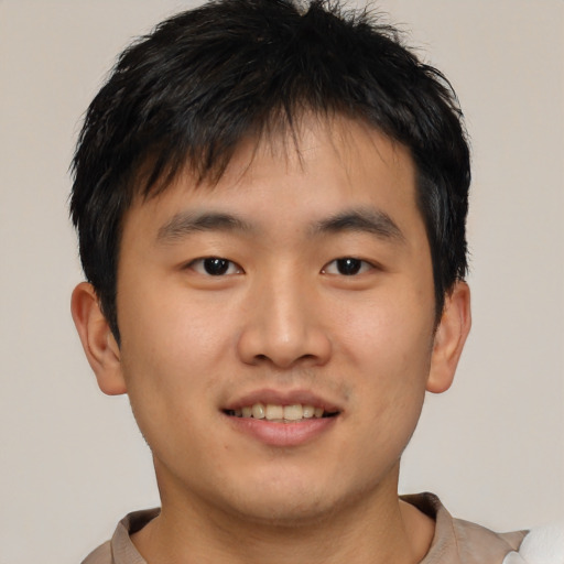 Joyful asian young-adult male with short  brown hair and brown eyes
