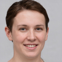 Joyful white young-adult female with short  brown hair and grey eyes