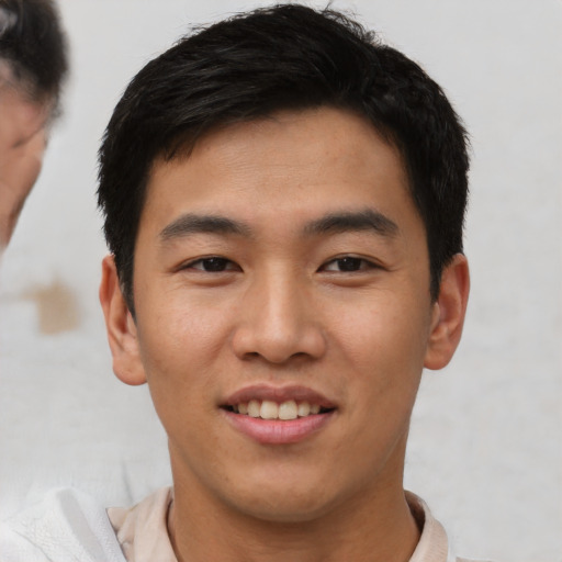Joyful asian young-adult male with short  black hair and brown eyes