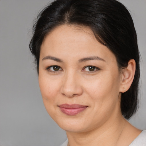 Joyful asian adult female with medium  brown hair and brown eyes