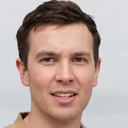 Joyful white young-adult male with short  brown hair and grey eyes