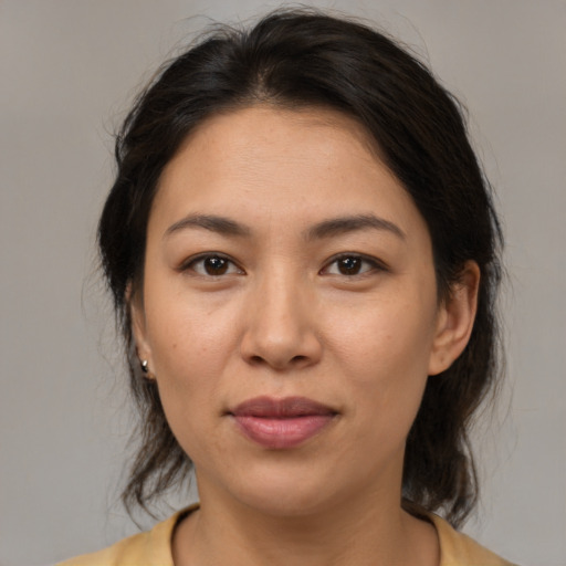 Joyful latino adult female with medium  brown hair and brown eyes