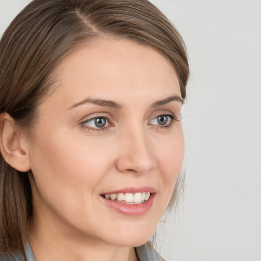 Joyful white young-adult female with long  brown hair and blue eyes