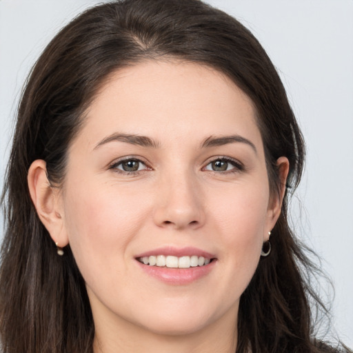 Joyful white young-adult female with long  brown hair and brown eyes