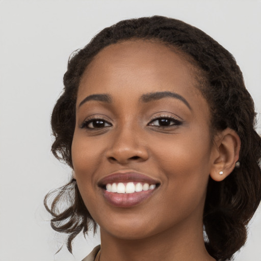 Joyful black young-adult female with long  brown hair and brown eyes