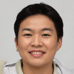 Joyful asian young-adult male with short  brown hair and brown eyes