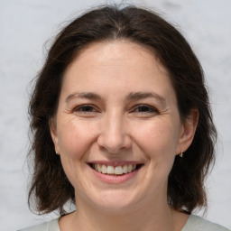 Joyful white adult female with medium  brown hair and brown eyes