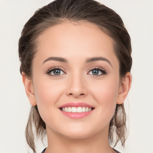 Joyful white young-adult female with long  brown hair and grey eyes