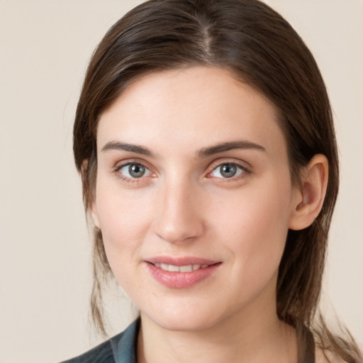 Joyful white young-adult female with medium  brown hair and grey eyes