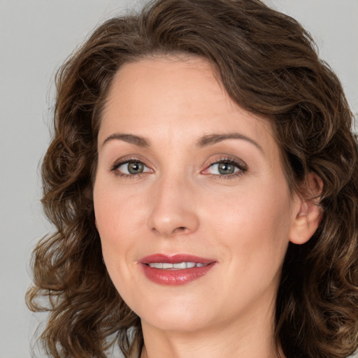 Joyful white adult female with long  brown hair and green eyes