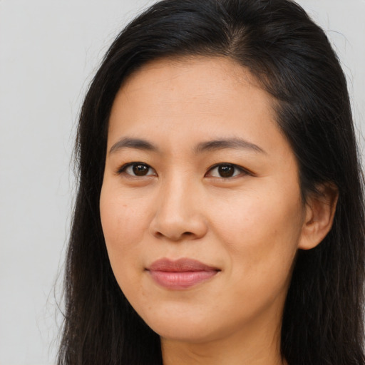 Joyful asian young-adult female with long  brown hair and brown eyes