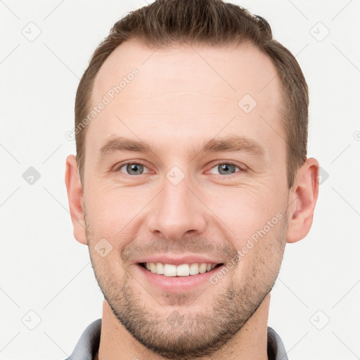 Joyful white young-adult male with short  brown hair and grey eyes