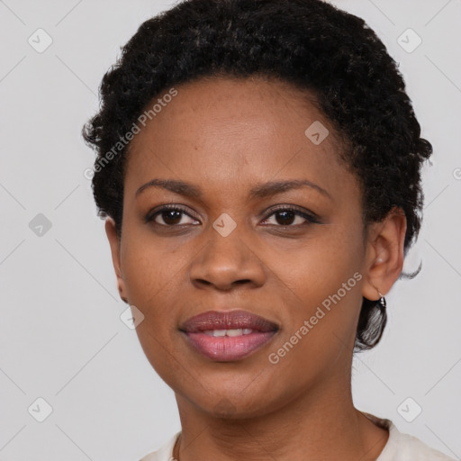 Joyful black young-adult female with short  black hair and brown eyes