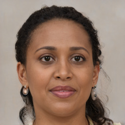 Joyful black adult female with medium  brown hair and brown eyes