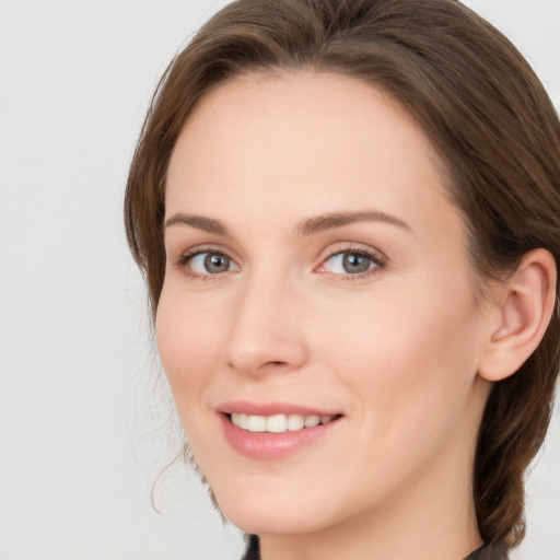 Joyful white young-adult female with long  brown hair and blue eyes