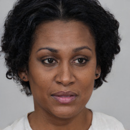 Joyful black adult female with short  brown hair and brown eyes