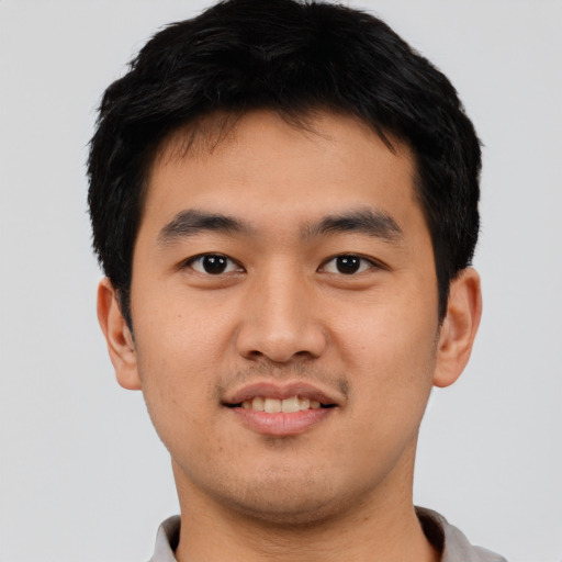 Joyful asian young-adult male with short  black hair and brown eyes