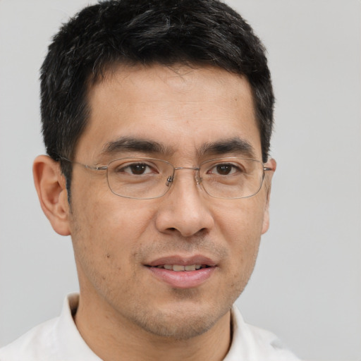 Joyful asian adult male with short  brown hair and brown eyes