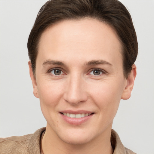 Joyful white young-adult female with short  brown hair and grey eyes