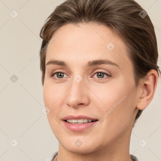 Joyful white young-adult female with short  brown hair and grey eyes