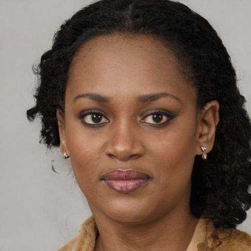 Joyful black young-adult female with long  brown hair and brown eyes