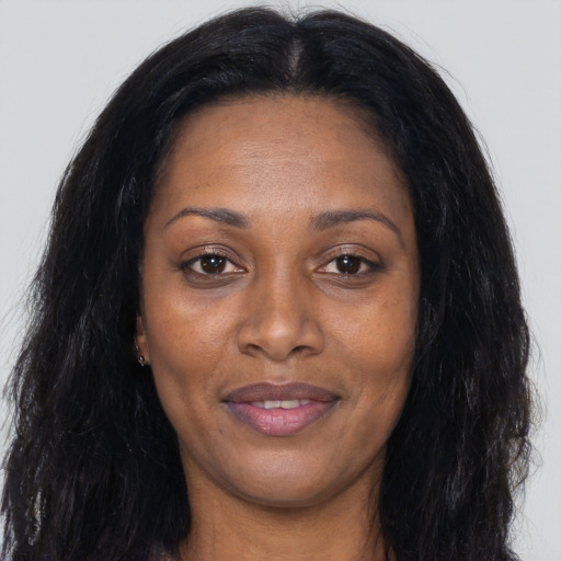 Joyful black young-adult female with long  black hair and brown eyes