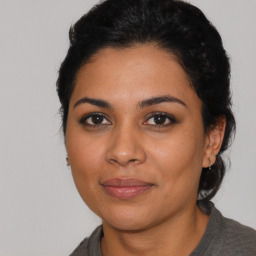 Joyful latino young-adult female with medium  black hair and brown eyes