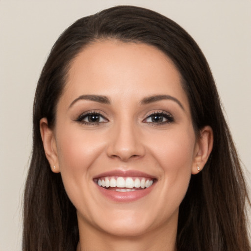 Joyful white young-adult female with long  brown hair and brown eyes