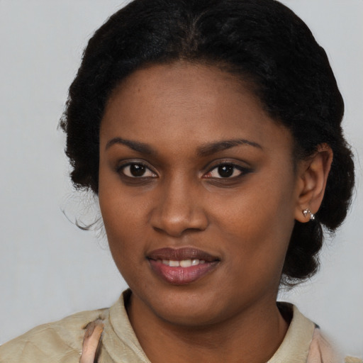 Joyful black young-adult female with long  black hair and brown eyes