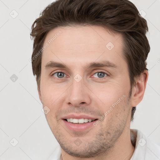 Joyful white young-adult male with short  brown hair and grey eyes