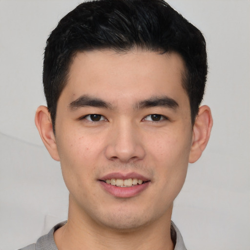 Joyful white young-adult male with short  black hair and brown eyes