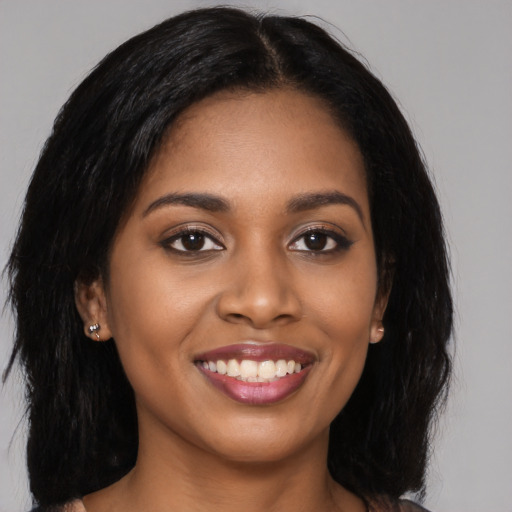 Joyful black young-adult female with long  brown hair and brown eyes