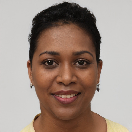 Joyful black young-adult female with short  brown hair and brown eyes