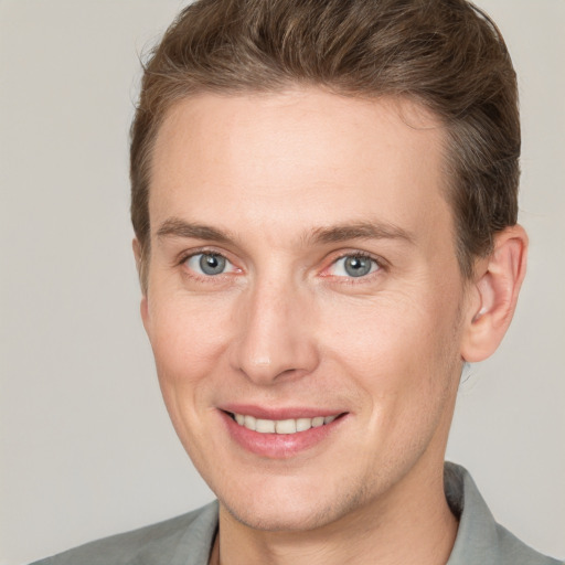 Joyful white adult male with short  brown hair and grey eyes