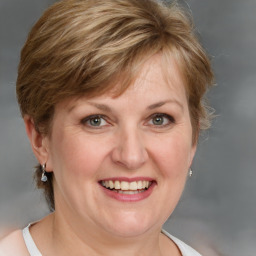 Joyful white adult female with medium  brown hair and blue eyes