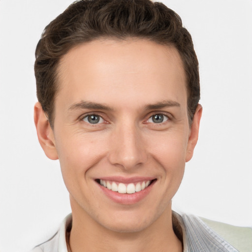 Joyful white young-adult male with short  brown hair and grey eyes