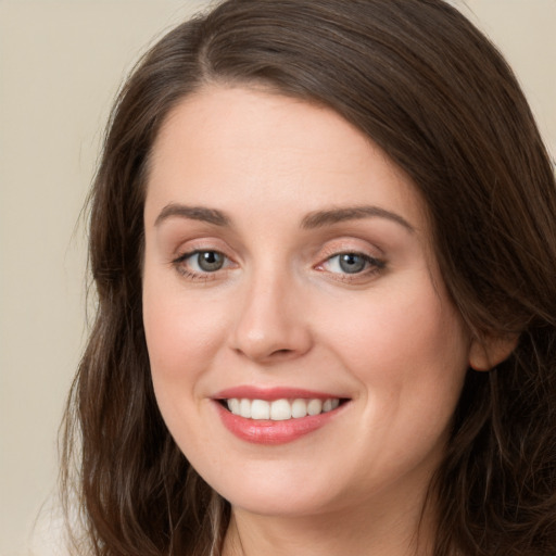 Joyful white young-adult female with long  brown hair and grey eyes