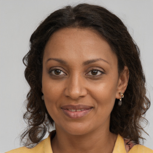 Joyful black young-adult female with long  brown hair and brown eyes