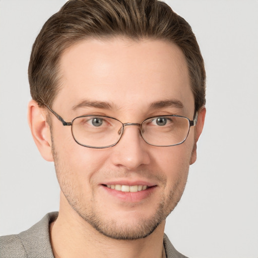 Joyful white young-adult male with short  brown hair and grey eyes