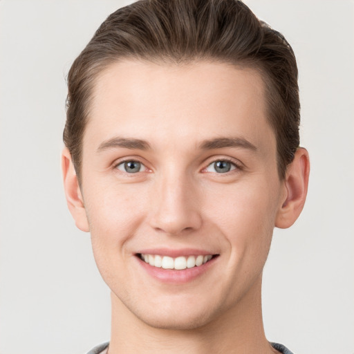 Joyful white young-adult male with short  brown hair and grey eyes