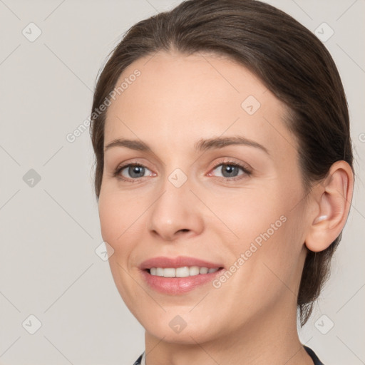 Joyful white young-adult female with medium  brown hair and grey eyes