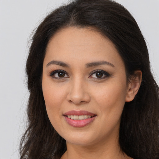 Joyful latino young-adult female with long  brown hair and brown eyes