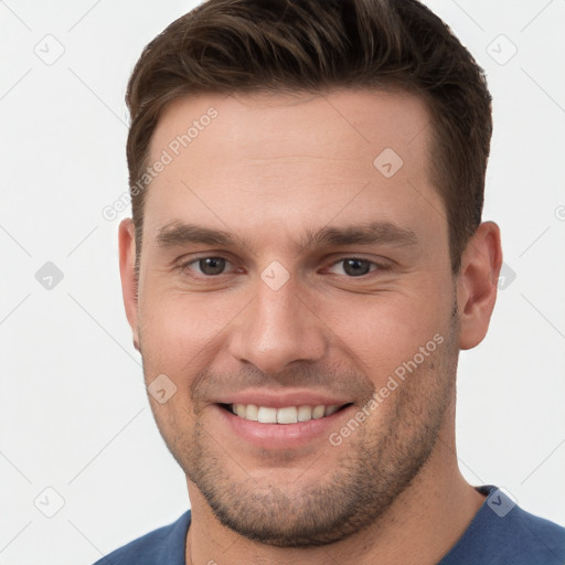 Joyful white young-adult male with short  brown hair and grey eyes