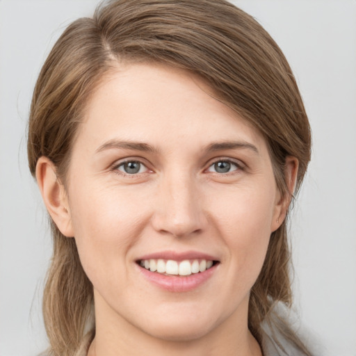 Joyful white young-adult female with medium  brown hair and grey eyes