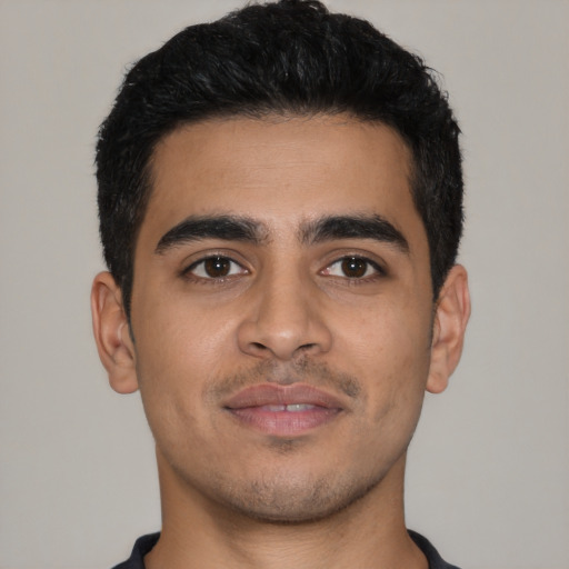 Joyful latino young-adult male with short  black hair and brown eyes