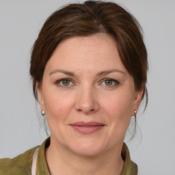 Joyful white adult female with medium  brown hair and grey eyes