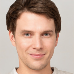 Joyful white young-adult male with short  brown hair and grey eyes